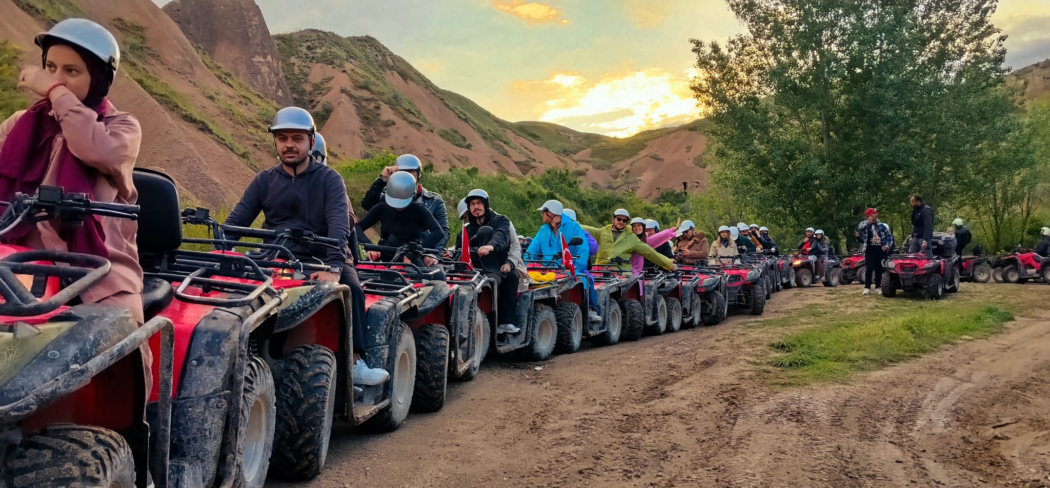 Kapadokya vadisinde gün batımına doğru sıralanan ATV safari grubu